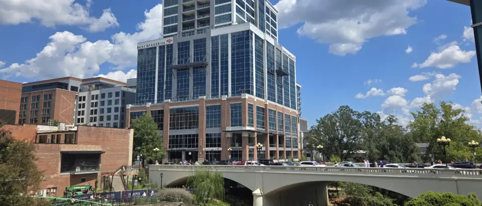 Falls Park on the Reedy River in downtown Greenville, SC, with bridges, towers and a blue sky